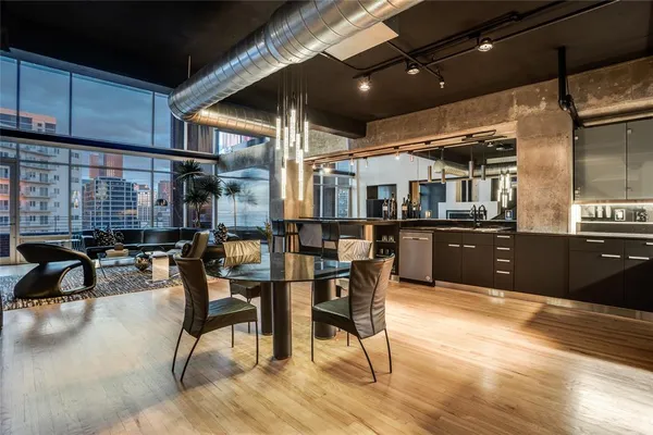 a open kitchen with stainless steel appliances kitchen island granite countertop a table and chairs in it