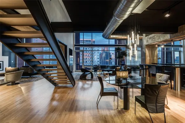 a dining room with wooden floor table and chairs