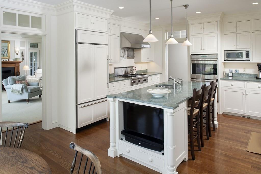 523 Barneys Joy Road Dartmouth, MA 02748 - Photo 9 of 39 a kitchen with stainless steel appliances a stove a refrigerator a oven a sink a dining table and chairs with wooden floor