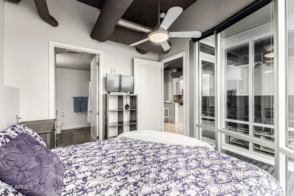 a bedroom with a bed closet and flat screen tv