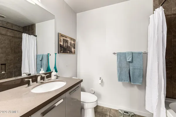 a bathroom with a granite countertop sink toilet and mirror