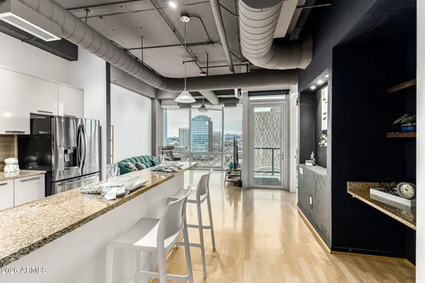 a large white kitchen with a large window and stainless steel appliances