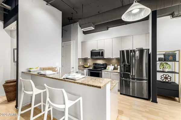a kitchen with granite countertop a refrigerator and microwave