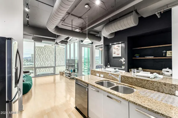 a kitchen with stainless steel appliances granite countertop a sink a stove and a refrigerator