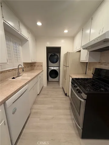 a large kitchen with stainless steel appliances granite countertop a stove and a sink