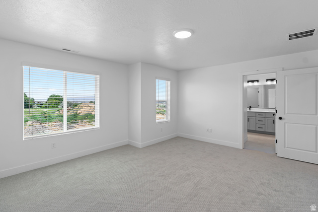 2816 West Aurora Avenue Mapleton, UT 84664 - Photo 8 of 20 Unfurnished bedroom featuring light colored carpet, connected bathroom, and a textured ceiling