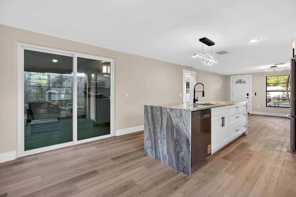 5612 Mallow Street New Port Richey, FL 34652 - Photo 11 of 43 a kitchen with stainless steel appliances kitchen island wooden floors and white walls