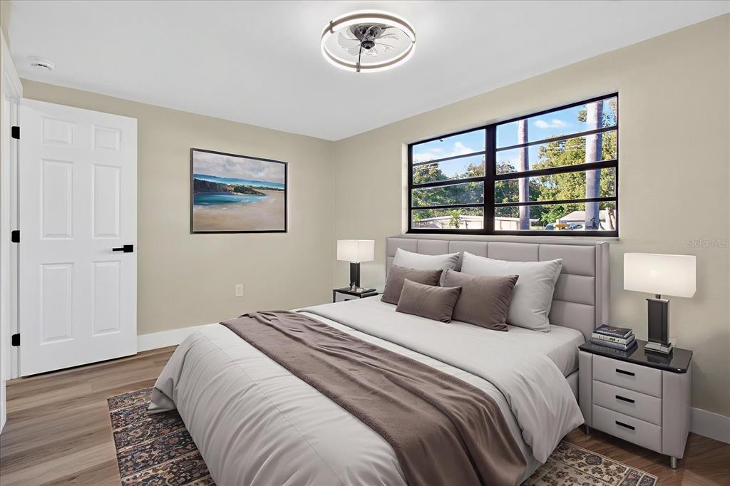 5612 Mallow Street New Port Richey, FL 34652 - Photo 20 of 43 a bedroom with a bed and a lamp on dresser with a window