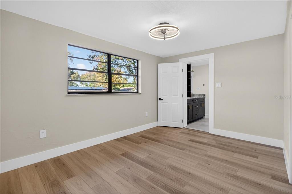 5612 Mallow Street New Port Richey, FL 34652 - Photo 22 of 43 an empty room with wooden floor and windows