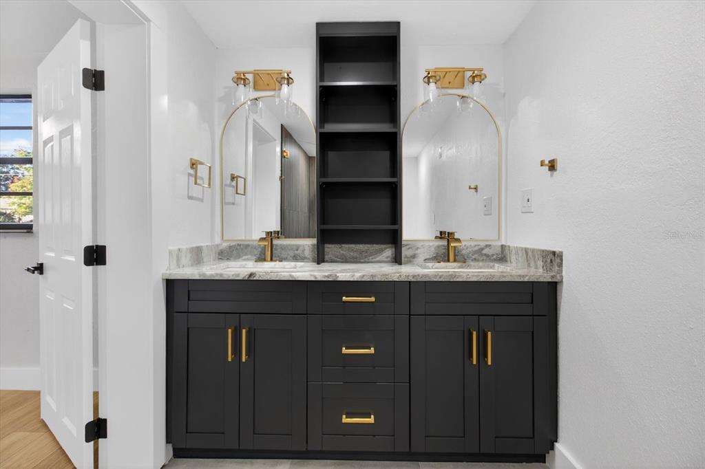 5612 Mallow Street New Port Richey, FL 34652 - Photo 23 of 43 a bathroom with a granite countertop sink a toilet and a mirror