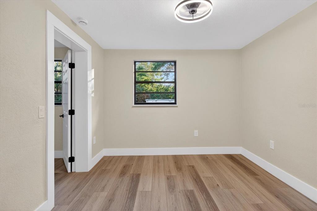 5612 Mallow Street New Port Richey, FL 34652 - Photo 32 of 43 an empty room with wooden floor and windows