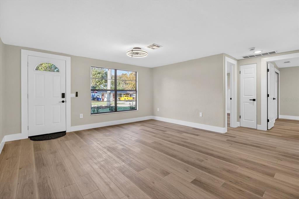 5612 Mallow Street New Port Richey, FL 34652 - Photo 4 of 43 an empty room with wooden floor and windows