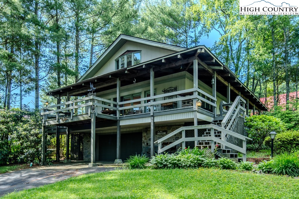 94 Rhododendron Loop Newland, NC 28657 - Photo 1 of 50 a view of a house with a small yard plants and large trees
