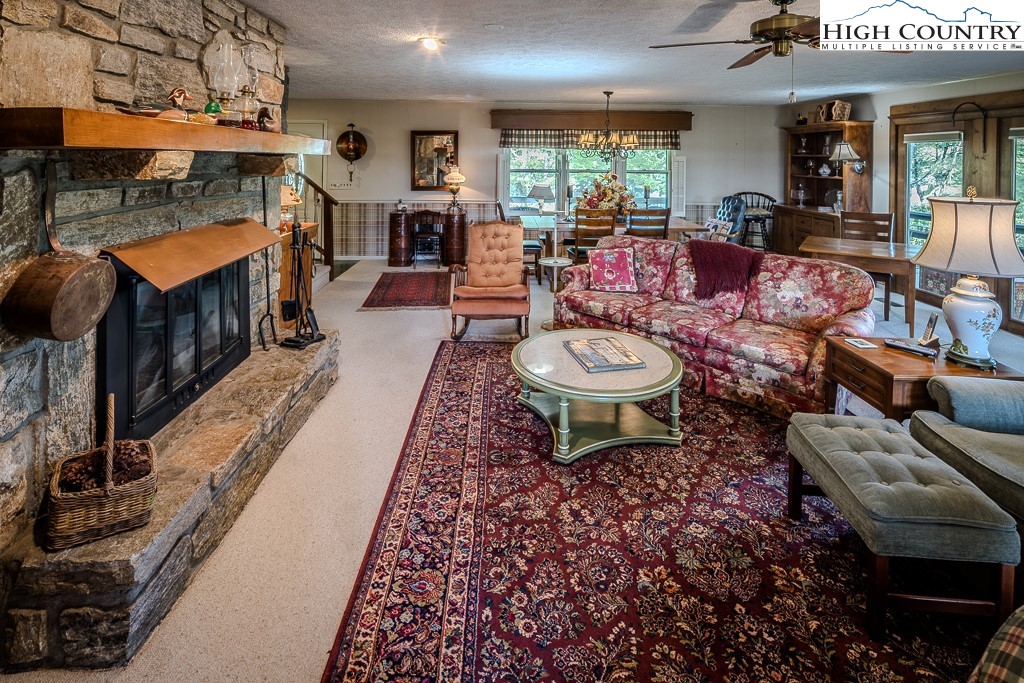94 Rhododendron Loop Newland, NC 28657 - Photo 16 of 50 a living room with furniture a rug and a floor to ceiling window
