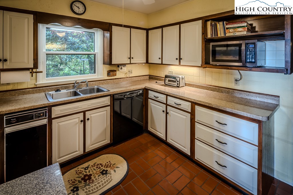 94 Rhododendron Loop Newland, NC 28657 - Photo 25 of 50 a kitchen with stainless steel appliances granite countertop a stove a sink and a microwave