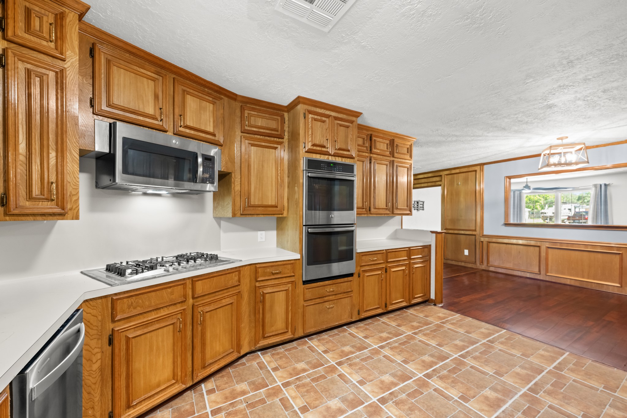 616 Cannan Drive Angleton, TX 77515 - Photo 14 of 49 A chef-friendly layout highlights this spacious kitchen, featuring extensive custom cabinetry, built-in double ovens, a gas cooktop, and generous prep space. The open design flows seamlessly into the adjoining dining area, making it ideal for both everyday cooking and effortless entertaining.