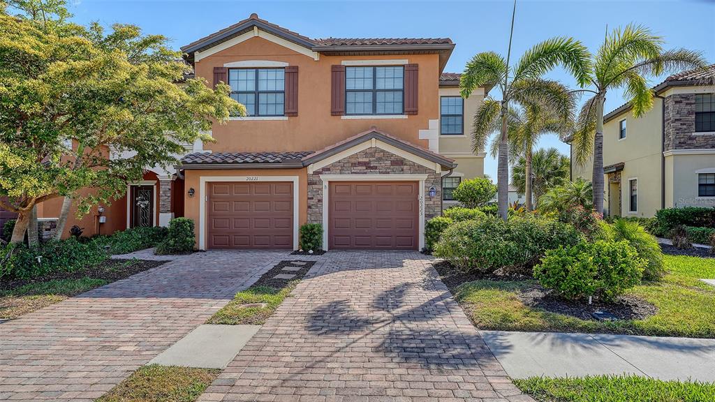 20223 Lagente Circle Venice, FL 34293 - Photo 2 of 71 a front view of a house with a garden and mountain view