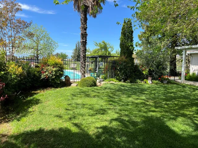 a view of a house with a big yard and potted plants