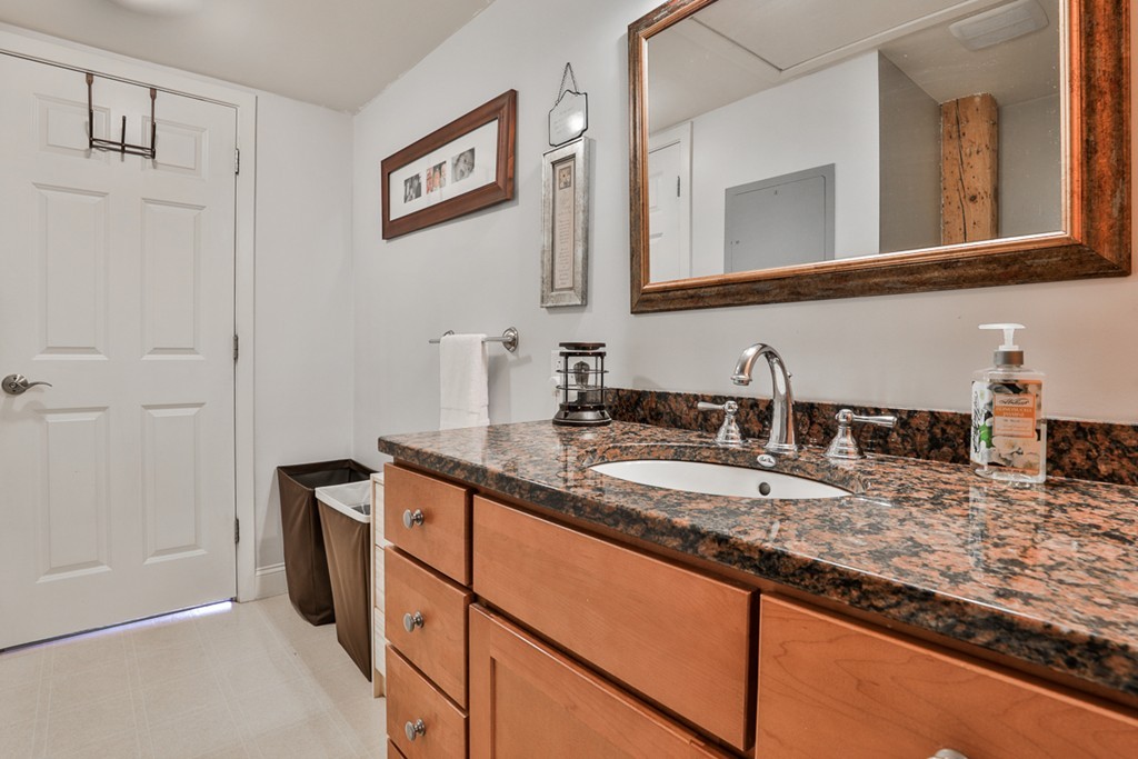 25 Cedar Street, Unit 4 Amesbury, MA 01913 - Photo 15 of 20 a bathroom with a granite countertop sink and a mirror