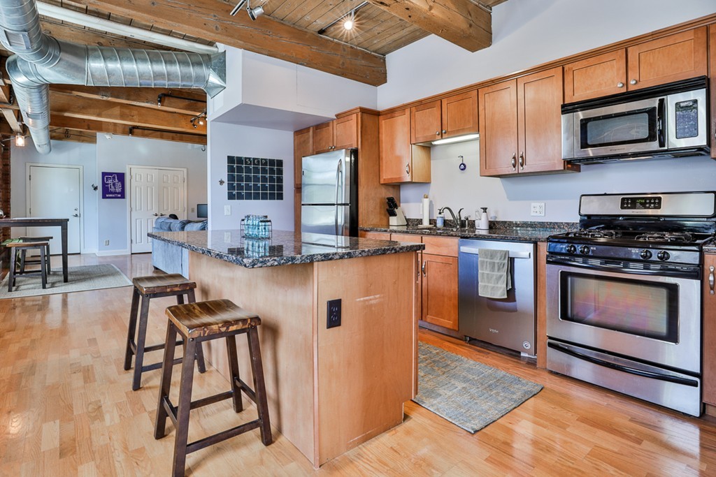 25 Cedar Street, Unit 4 Amesbury, MA 01913 - Photo 8 of 20 a kitchen with stainless steel appliances granite countertop a stove top oven a sink dishwasher and cabinets with wooden floor