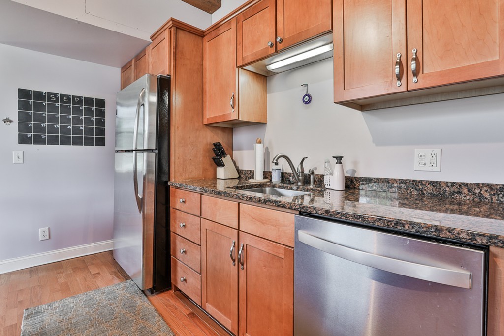 25 Cedar Street, Unit 4 Amesbury, MA 01913 - Photo 9 of 20 a kitchen with stainless steel appliances granite countertop a sink and a refrigerator