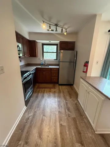 a kitchen with stainless steel appliances granite countertop a refrigerator and a stove