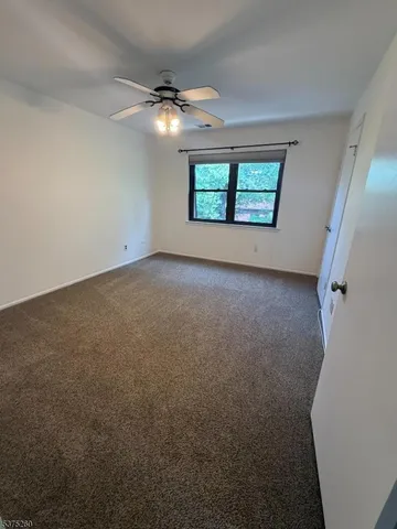 an empty room with windows and ceiling fan view