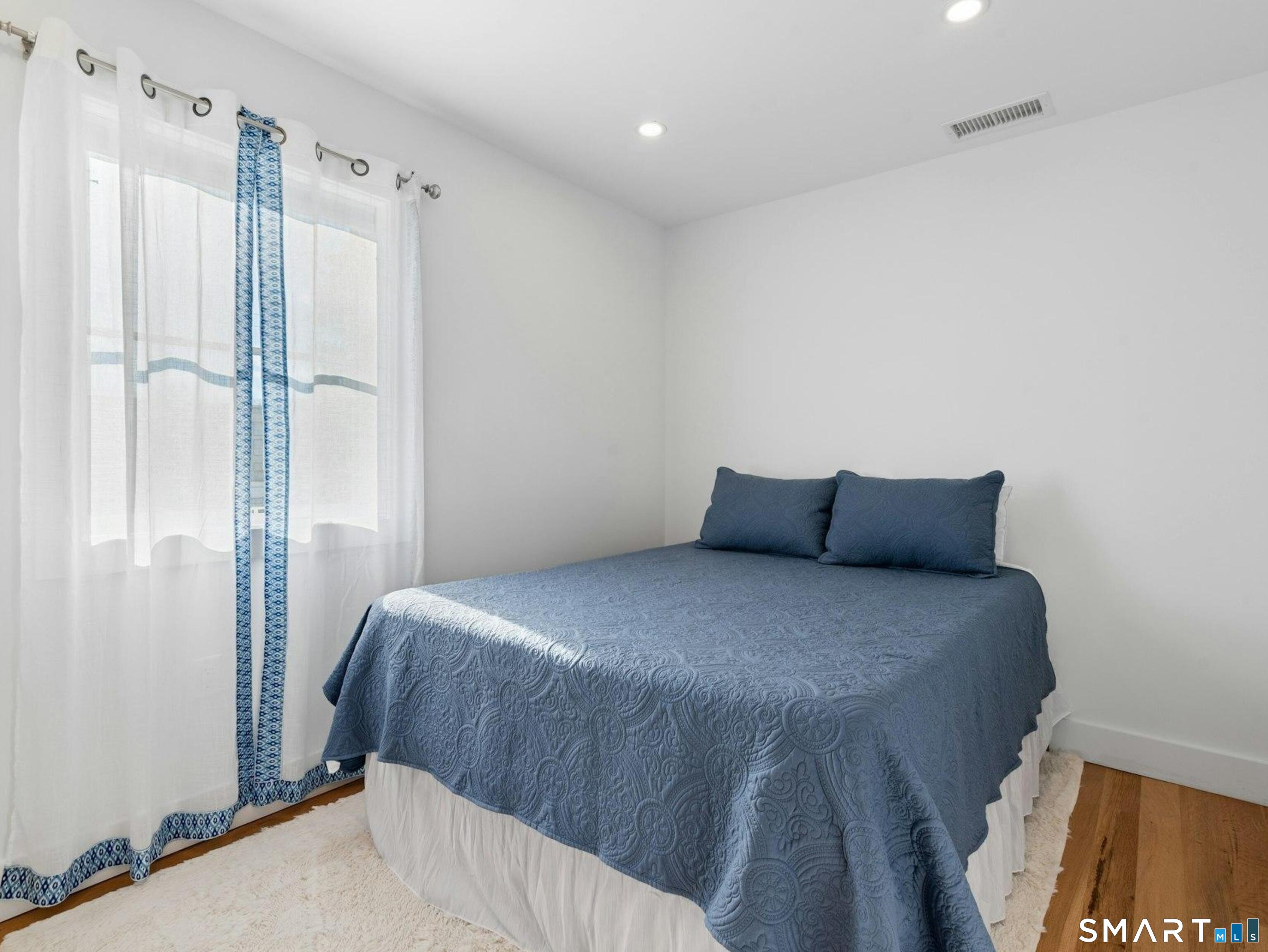 13 Patton Drive Darien, CT 06820 - Photo 19 of 26 a bed sitting in a bedroom next to a bathroom