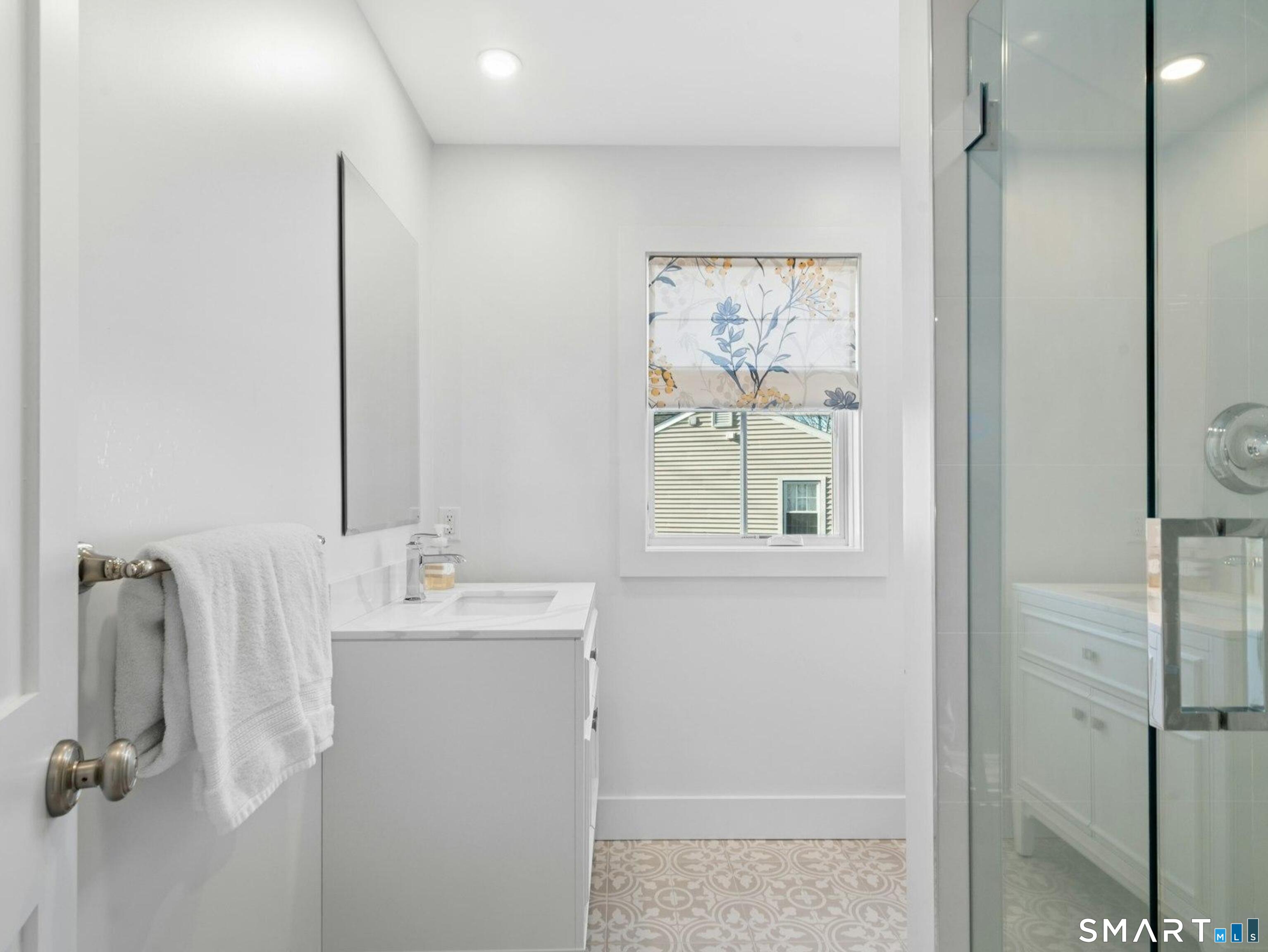 13 Patton Drive Darien, CT 06820 - Photo 20 of 26 a bathroom with a sink mirror and a shower