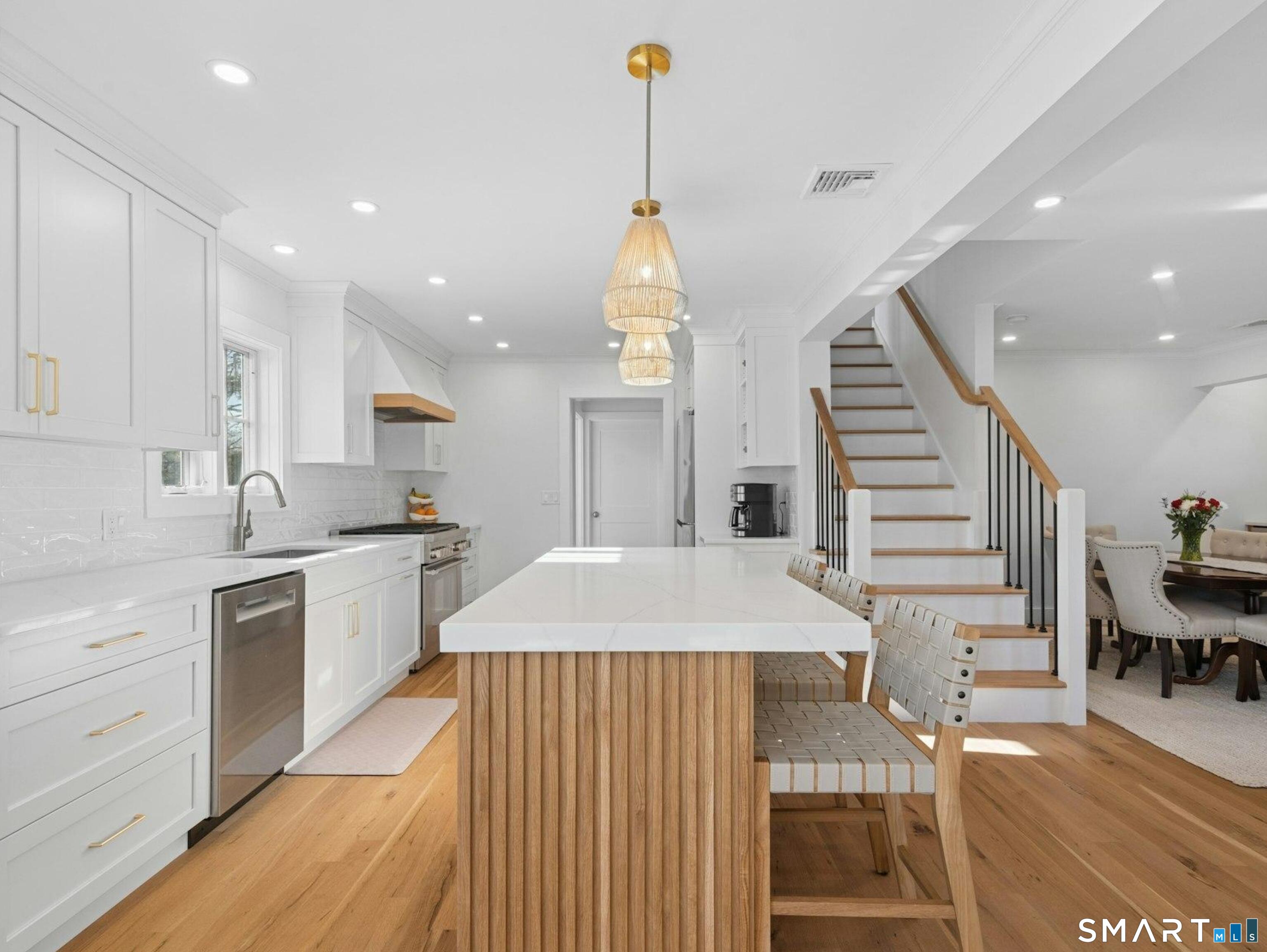 13 Patton Drive Darien, CT 06820 - Photo 9 of 26 a large kitchen with a table chairs wooden floors and a view of living room