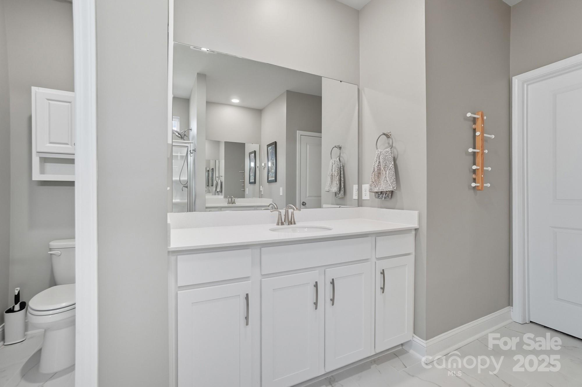 1325 Black Walnut Street Monroe, NC 28112 - Photo 20 of 46 a bathroom with a granite countertop sink a toilet and a mirror