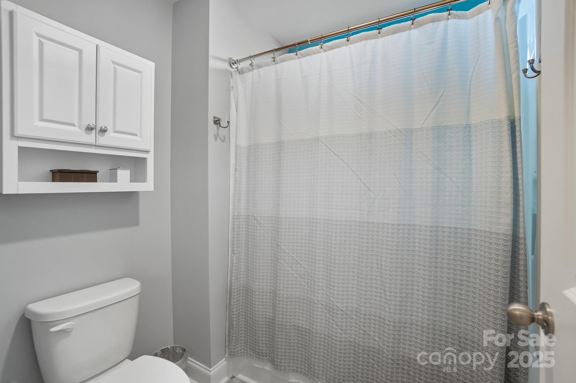 1325 Black Walnut Street Monroe, NC 28112 - Photo 37 of 46 a white toilet sitting next to a shower curtain