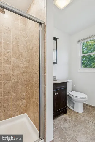 a bathroom with a toilet a sink a vanity and window