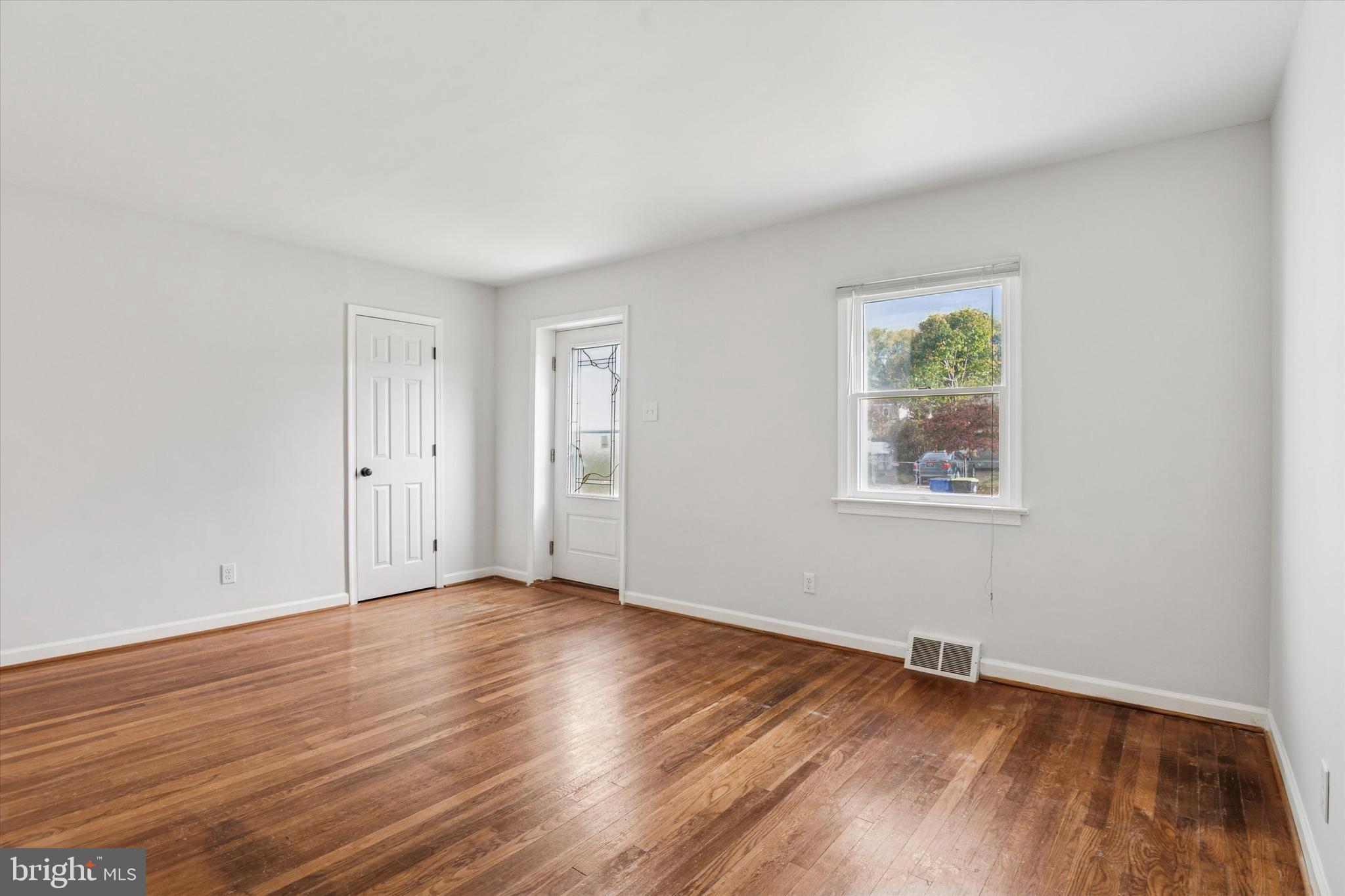 206 Decalb Avenue Wilmington, DE 19804 - Photo 2 of 14 an empty room with wooden floor and windows