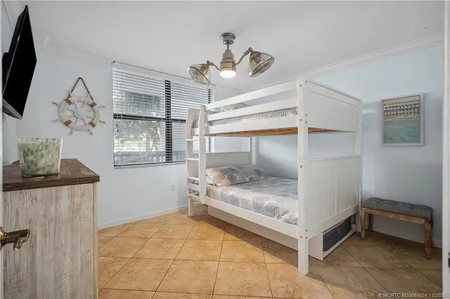 a bedroom with a bed and a flat tv screen on the wall