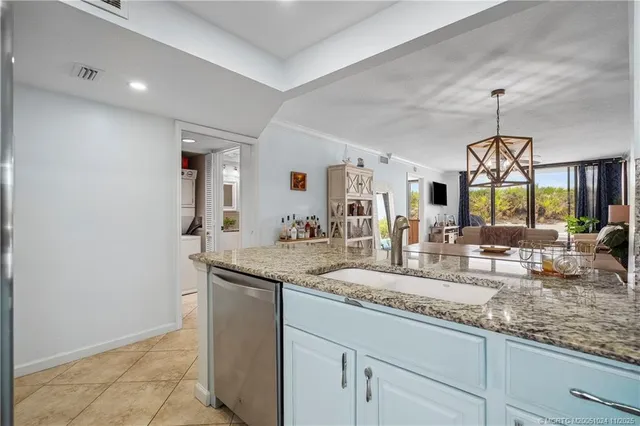 a kitchen with granite countertop a sink and a refrigerator