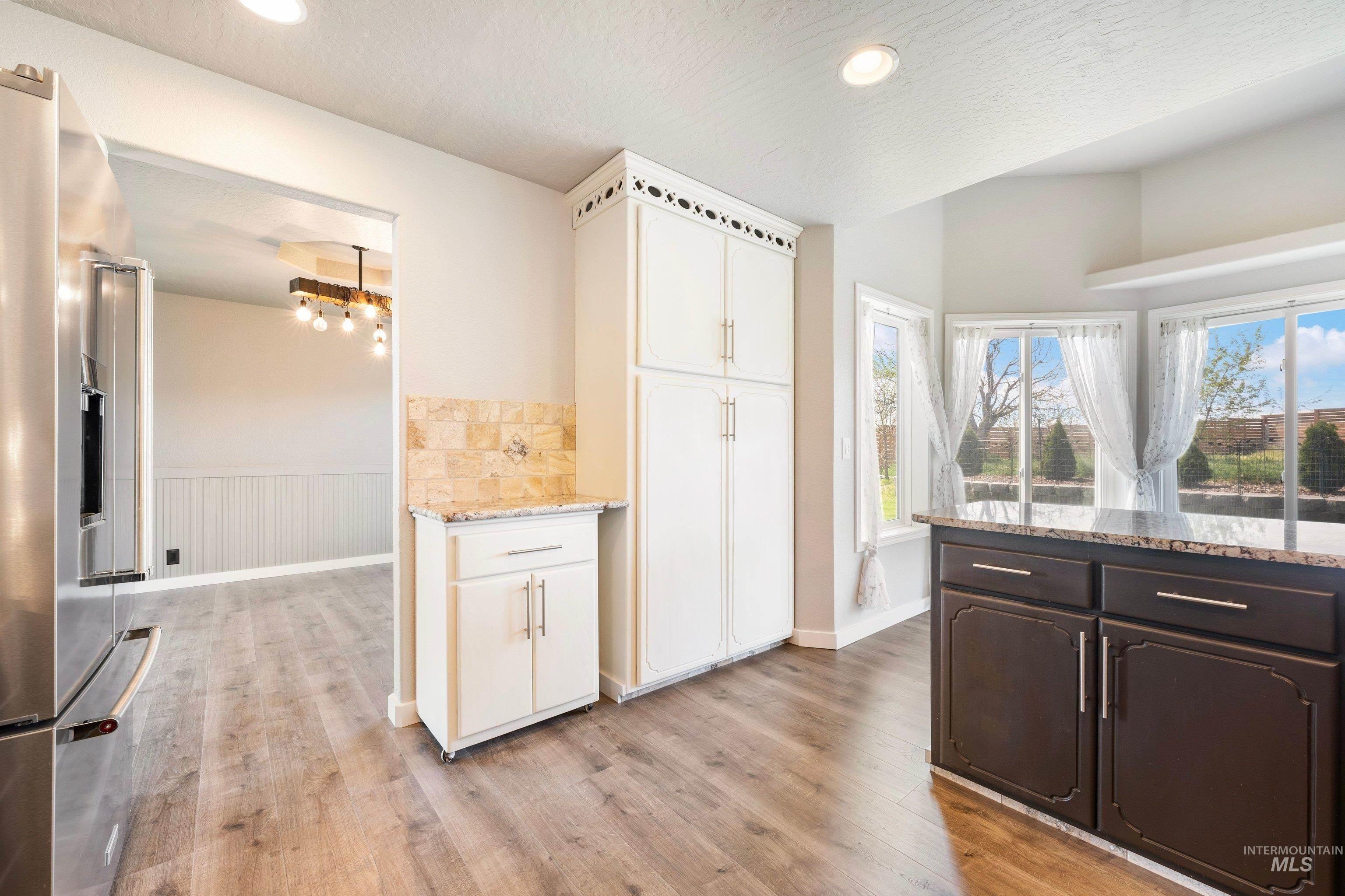 7657 Track Road Nampa, ID 83686 - Photo 14 of 49 Kitchen featuring wood-finish flooring, recessed lighting, and a bay window overlooking exterior landscaping