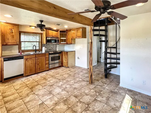 a kitchen with stainless steel appliances granite countertop a refrigerator and a sink