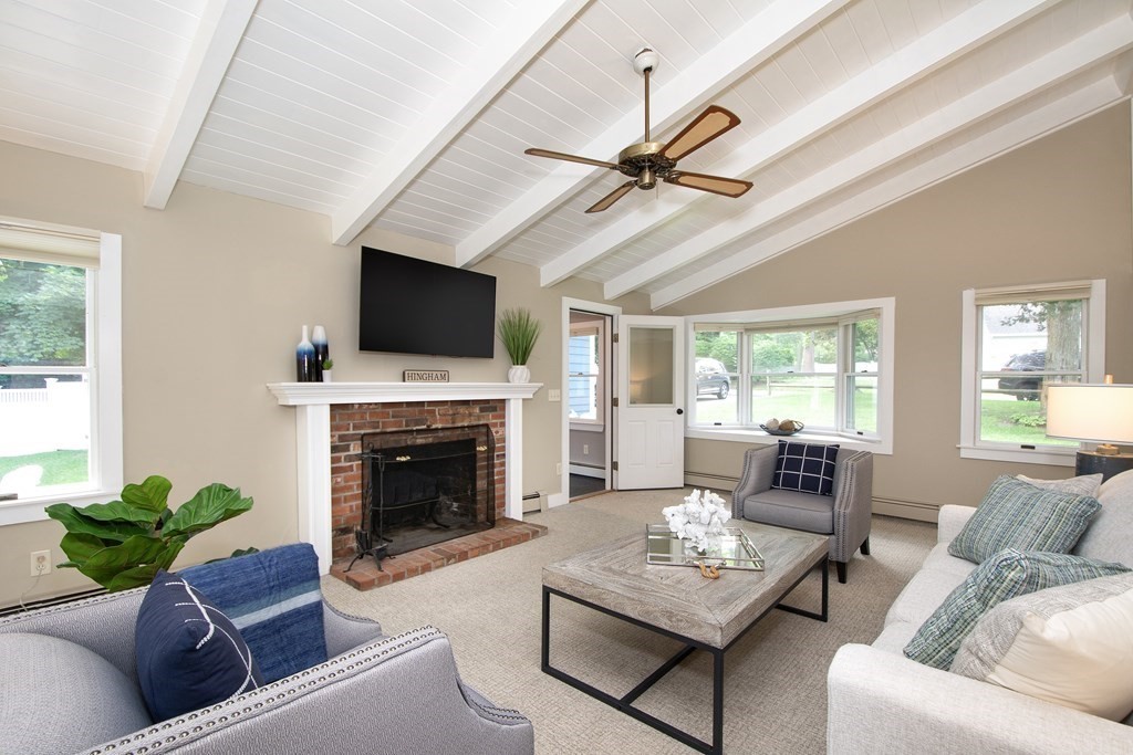18 Liberty Pole Road Hingham, MA 02043 - Photo 6 of 37 a living room with furniture a fireplace and a flat screen tv