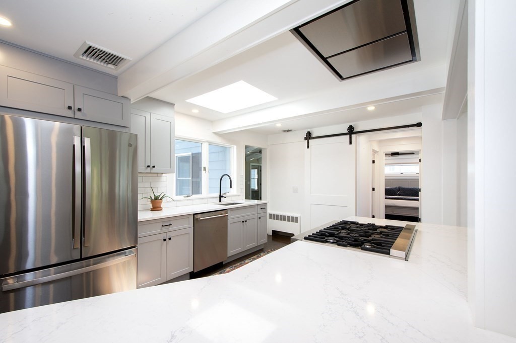 18 Liberty Pole Road Hingham, MA 02043 - Photo 8 of 37 a large white kitchen with a stove a refrigerator and a sink