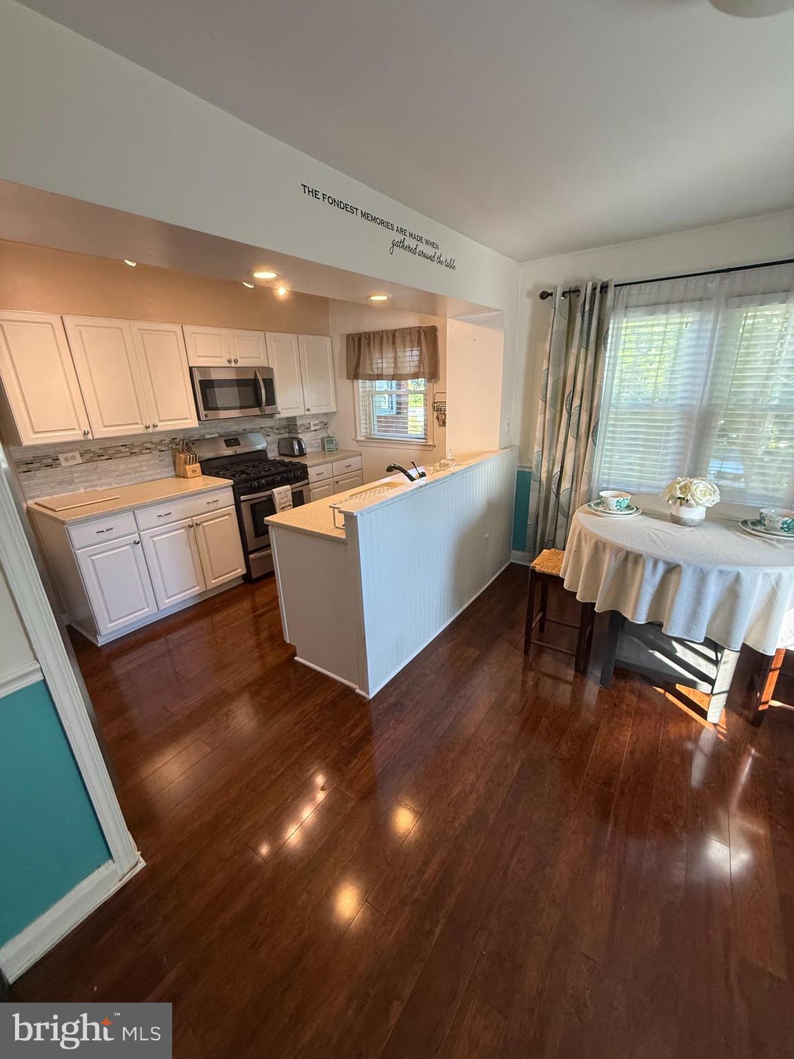 2235 Hawthorne Road Baltimore, MD 21220 - Photo 9 of 35 a living room with kitchen island furniture and a wooden floor