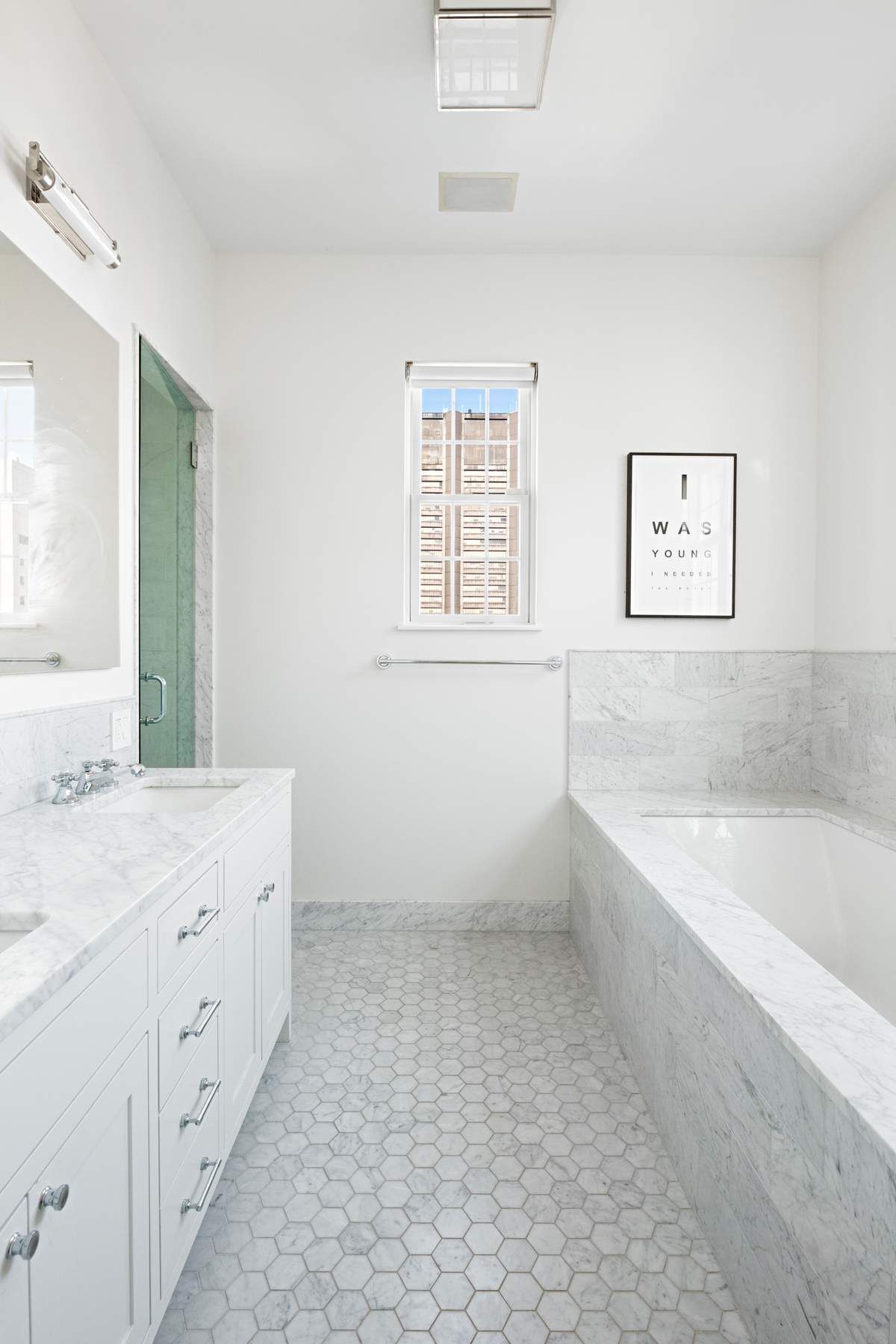 9 East 96th Street, Unit PH Manhattan, NY 10128 - Photo 11 of 18 a bathroom with a granite countertop sink a large mirror a bathtub and next to a window
