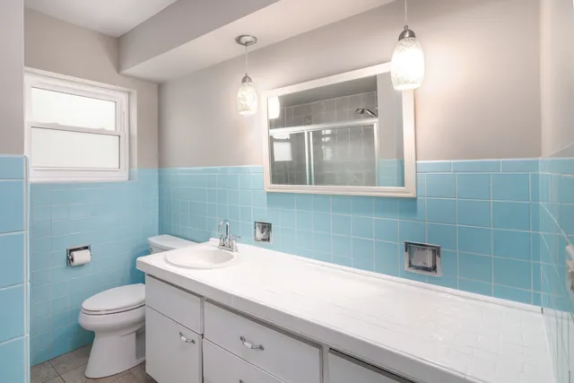 a bathroom with a sink a toilet and mirror
