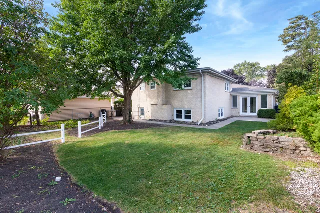 a view of a house with backyard and a tree