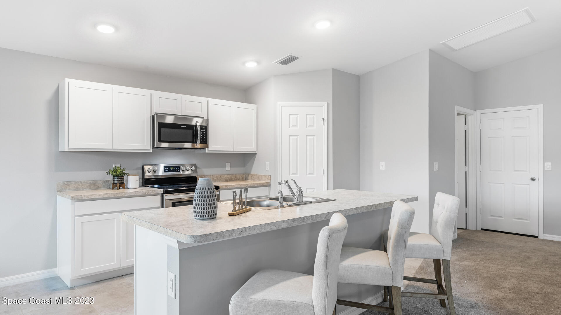1365 Ran Road Southeast Palm Bay, FL 32909 - Photo 4 of 15 a kitchen with sink a microwave a stove and refrigerator