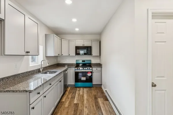 a kitchen with granite countertop stainless steel appliances and white cabinets