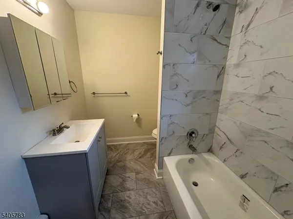 a bathroom with a sink and mirror with bathtub