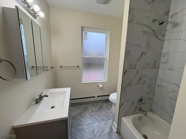 a bathroom with a tub sink and mirror