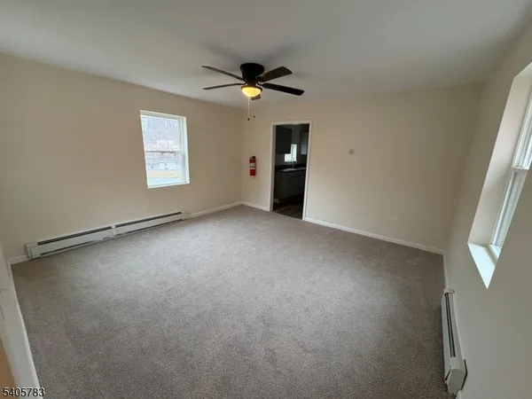 an empty room with a window and a ceiling fan