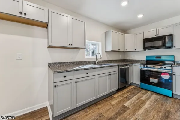 a kitchen with granite countertop a sink stainless steel appliances and cabinets